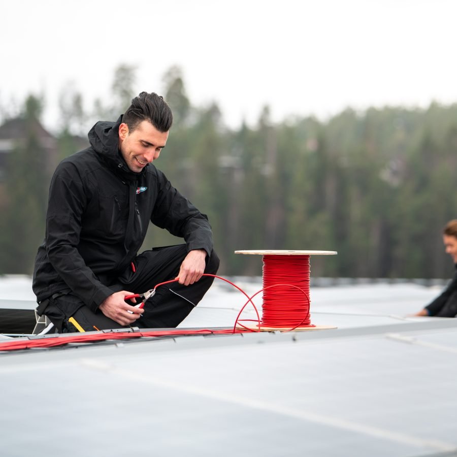 Elektriker monterer solcellepanel på tak